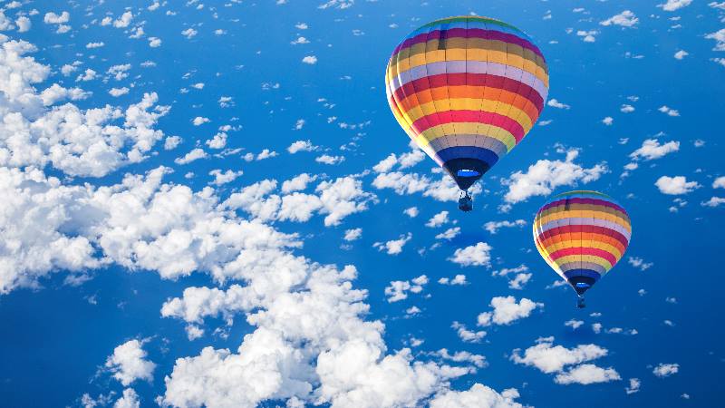 Colourful-hot-air-balloon-in sky-with-clouds-over-barcelona 