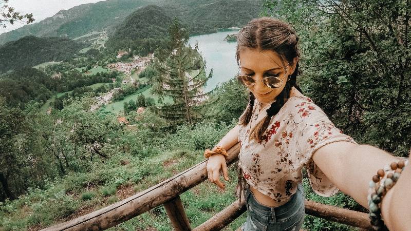 Lady-taking-selfie-with-countryside-background-travelling-solo