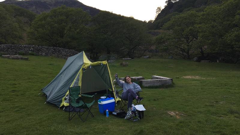 Lady-sitting-outside-a-tent-in-Wales-holding-a-beer-can-up