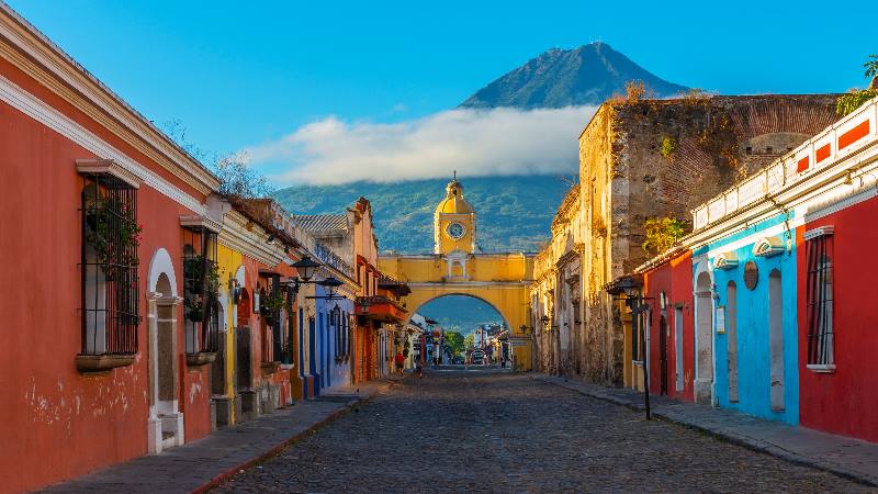 Street-scene-with-road-and-colourful-houses-A-volcano-in-the-background-in-Central-America