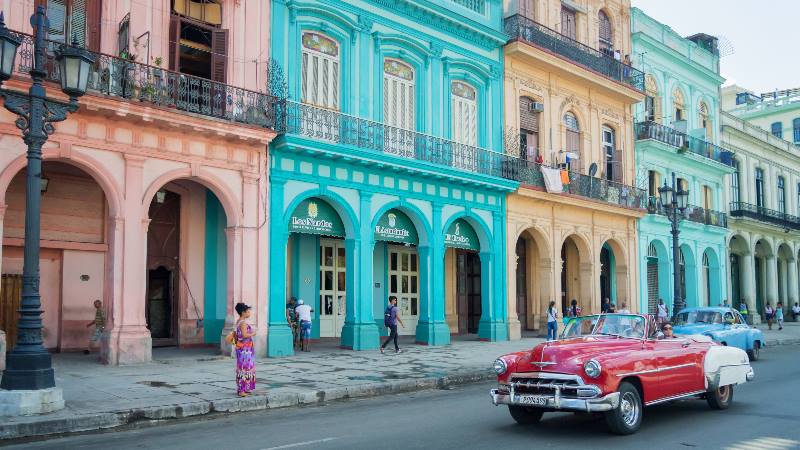 Street-scene-in-Havana-Central-America-Old-style-car-driving-down-a-colourful-street