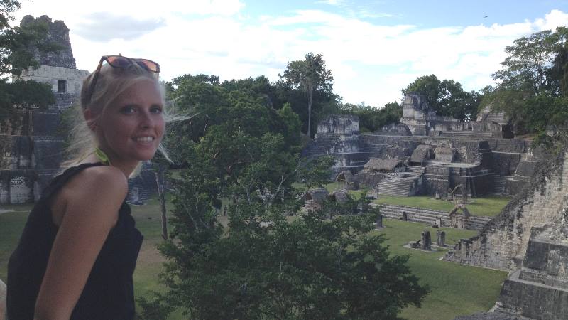 Author sitting on rocks with view of ruins in the background