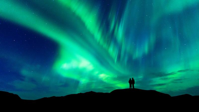 Two-people-watching-the-Northern-Lights-in-the-Winter