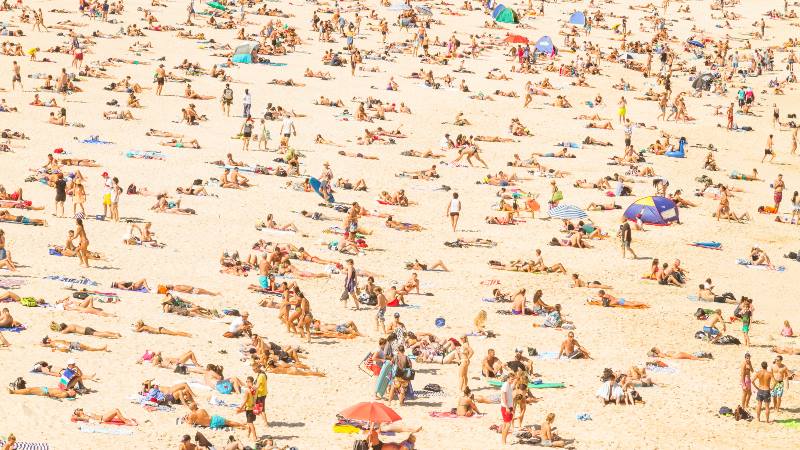 A-crowded-beach-scene-with-people-relaxing-travel-trends-for-2020