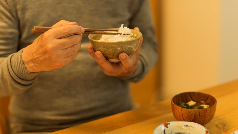 Man-holding-chopsticks-and-a-bowl-of-rice