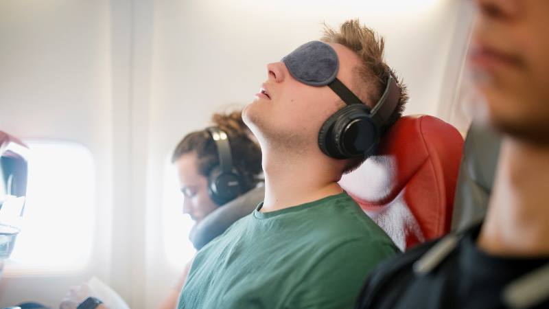 Man-with-face-mask-relaxing-on-a-plane-frequent-flyer-tips