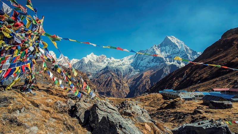 View-of-the-Annapurna-base-camp-with-flags-flying-in-the-foreground-mountains-to-climb 