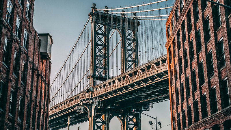 View of the Brooklyn bridge with houses leading up to it.