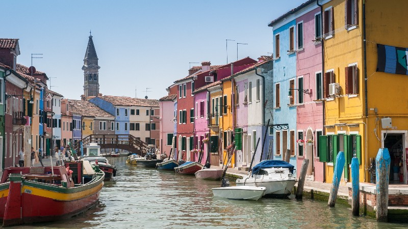 View of a canal heading into Murano and Burano with colourful buildings and boats near Venice View of a canal heading into Murano and Burano with colourful buildings and boats near Venice