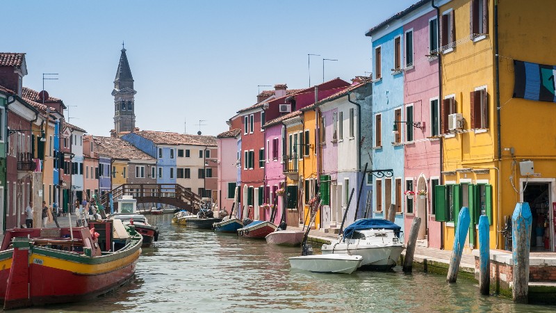 View of a canal heading into Murano and Burano with colourful buildings and boats near Venice