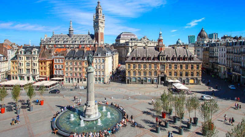 The main square in Lille. Fountain in the foreground and old buildings in the background